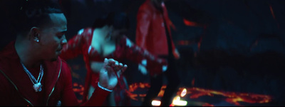 a man in a red jacket standing in a dark room