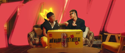 two men sitting on a couch in front of a box