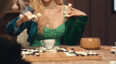 a woman sitting at a table with a cup of coffee