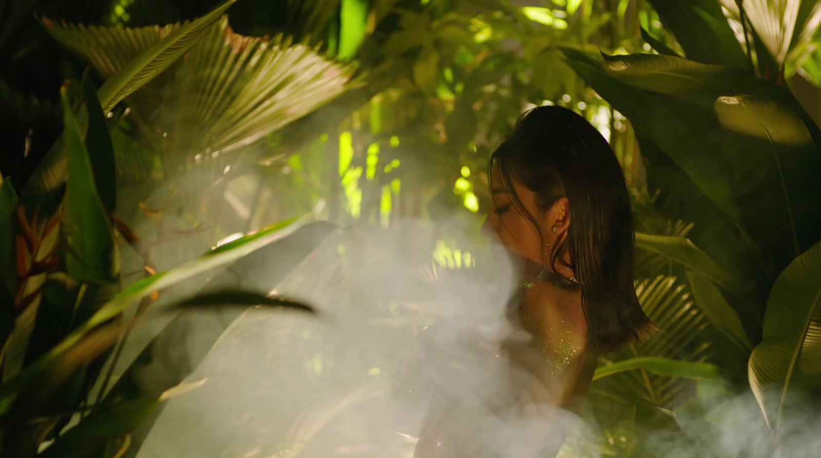 a woman standing in front of a lush green forest