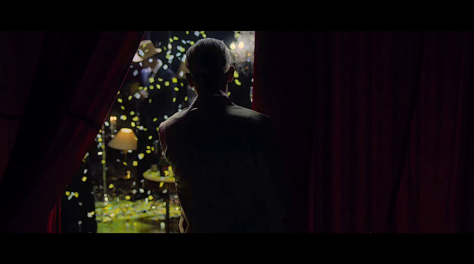 a man standing in front of a window looking at a christmas tree