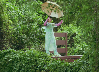 a woman in a green dress holding an umbrella