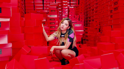 a woman kneeling down in a room full of red boxes