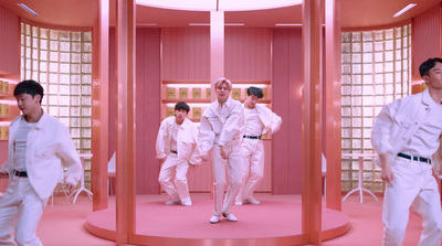 a group of men in white clothes walking through a room