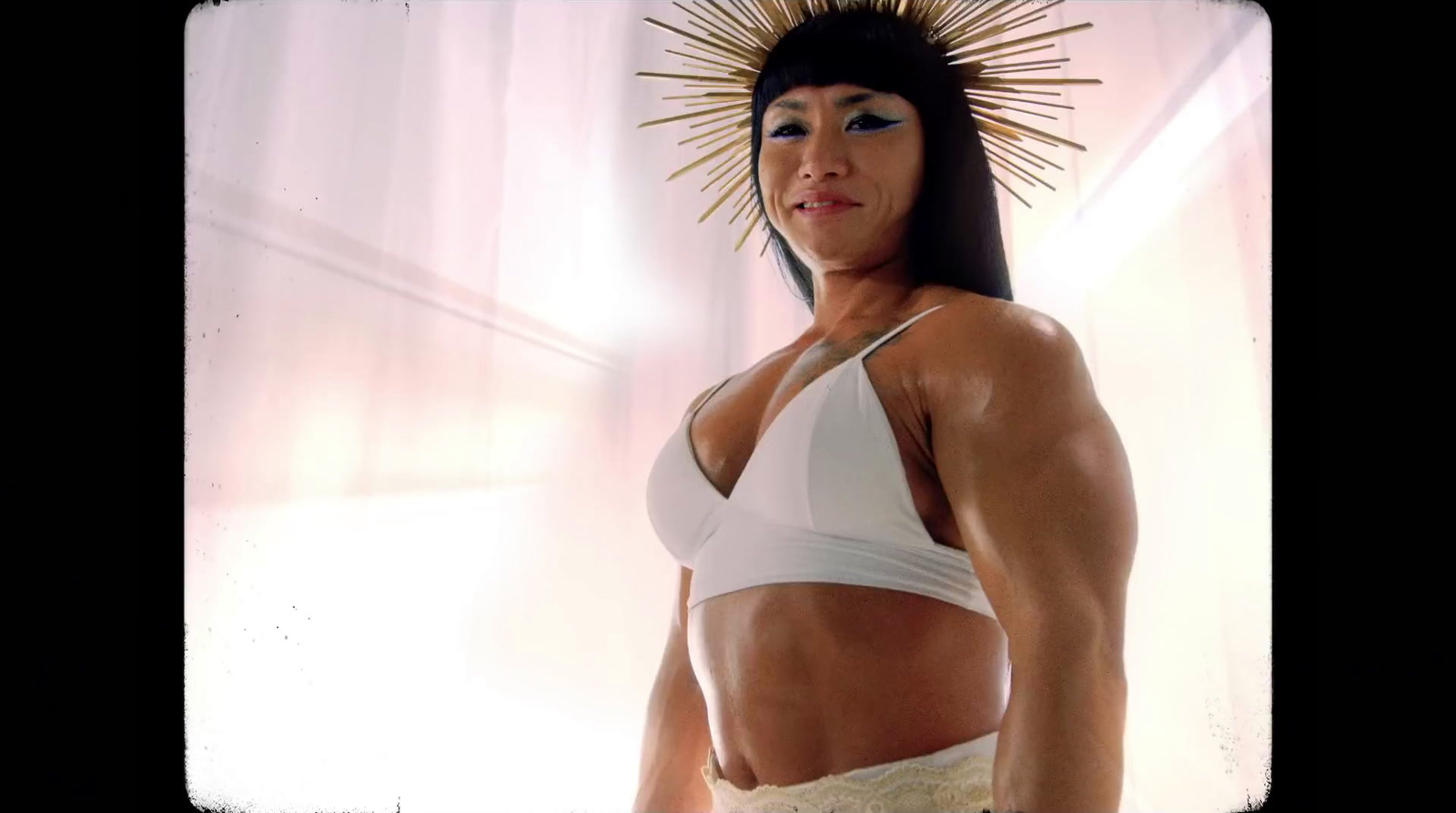 a woman in a white bikini with a gold crown on her head