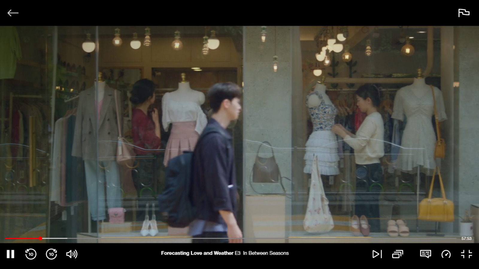 a man walking past a store window with mannequins in it