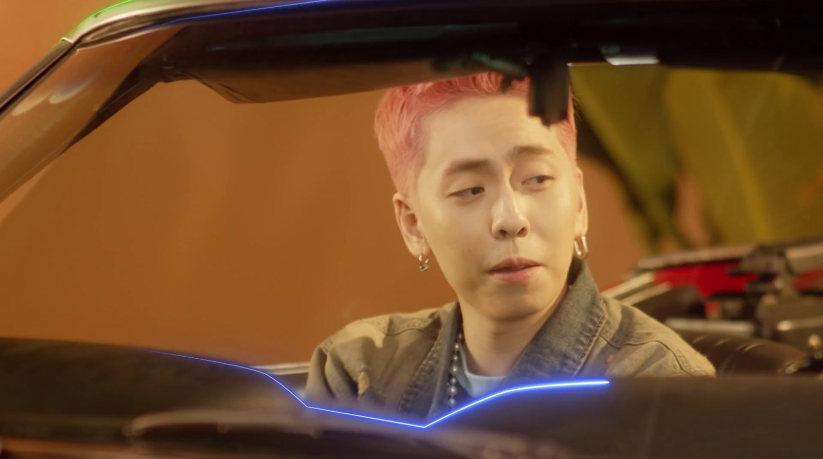 a man with pink hair sitting in a car