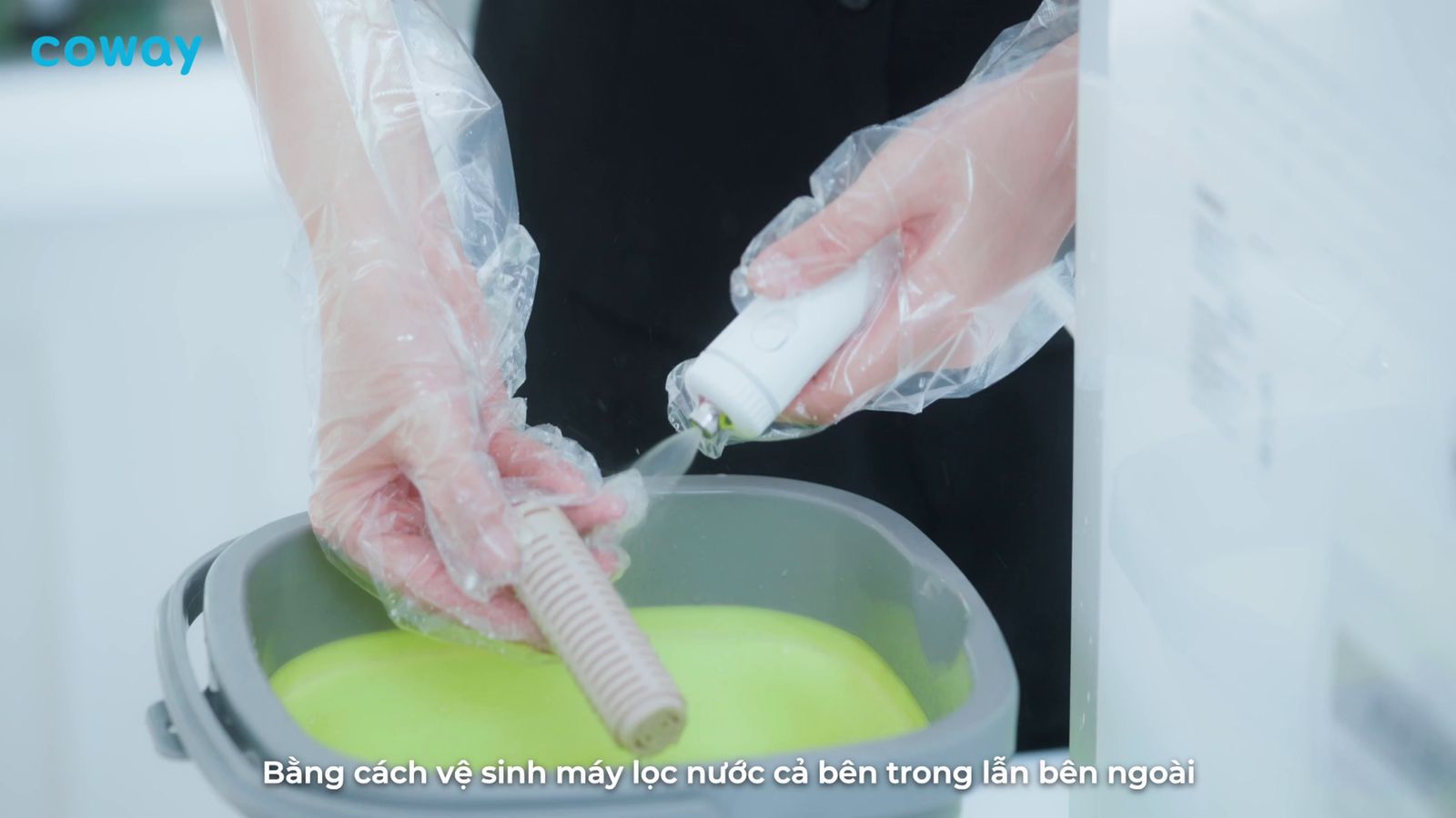 a person in a black shirt is cleaning a bucket