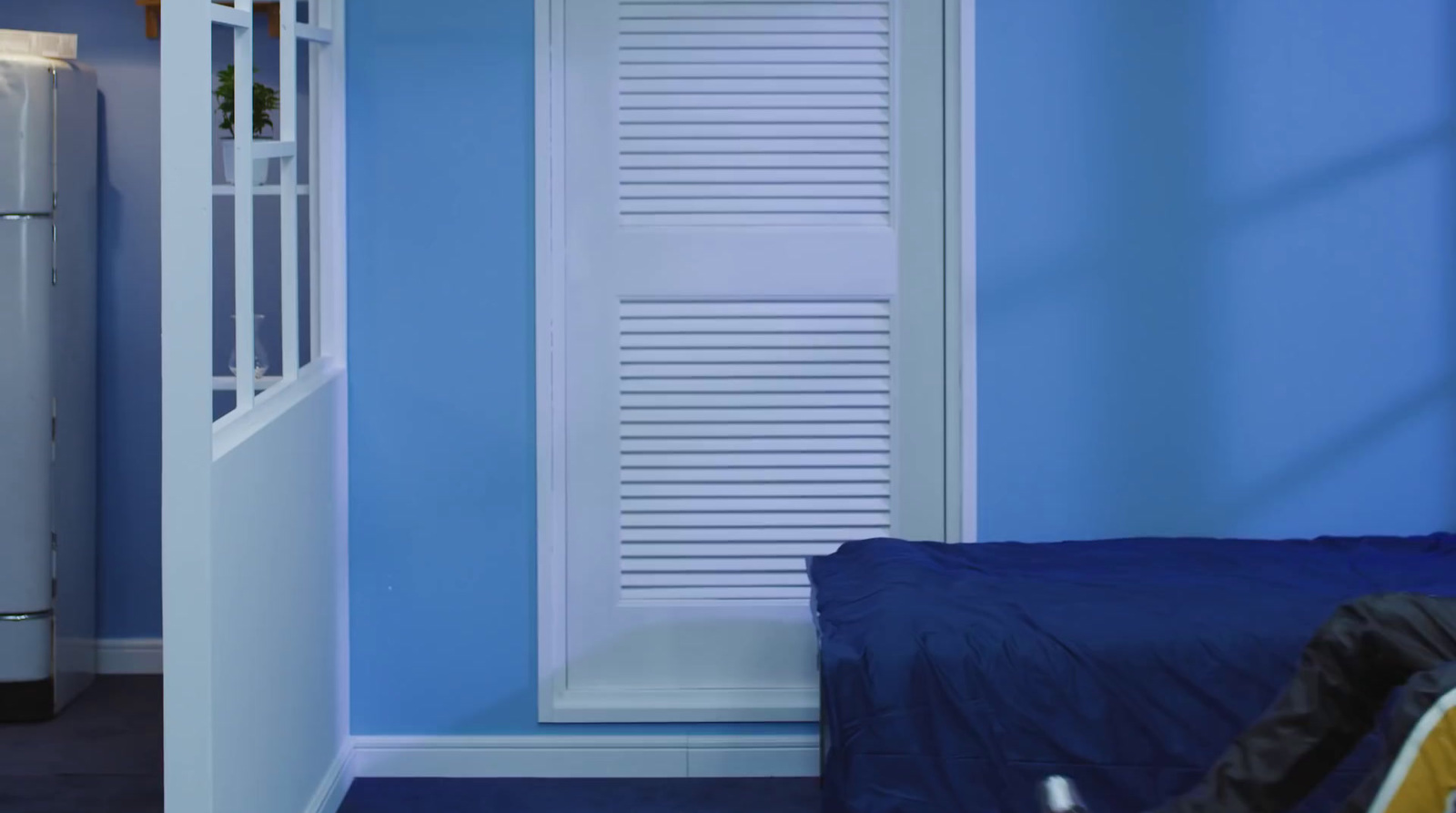 a bedroom with blue walls and a white door