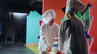 a couple of people that are standing in front of a cake