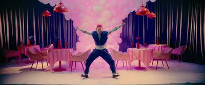 a man standing in front of a table with pink chairs