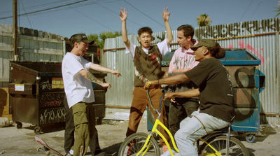 a group of men standing around a man on a bike