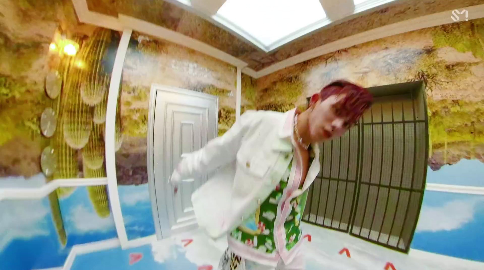 a man with red hair and a white jacket in a room