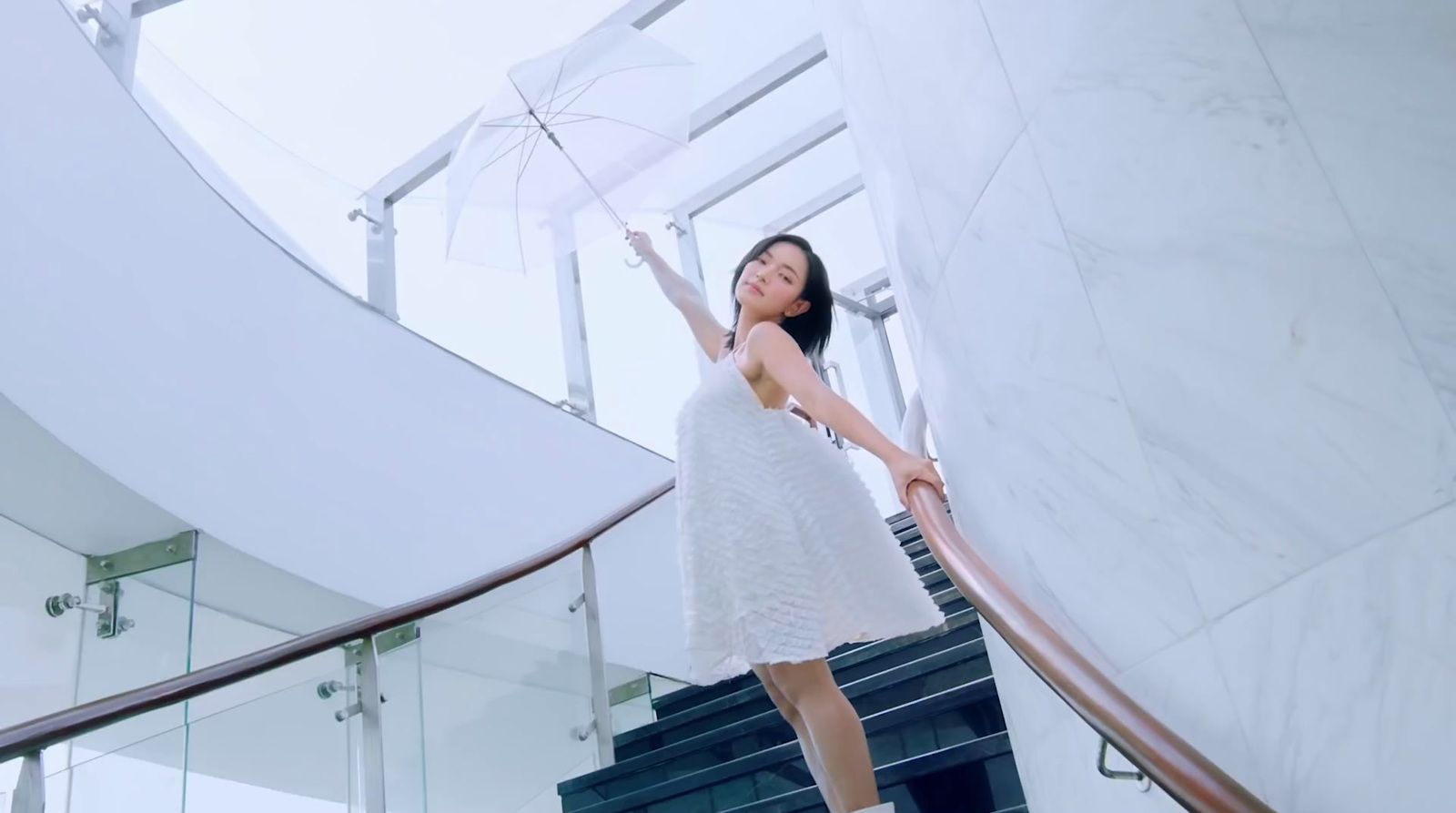 a woman in a white dress holding an umbrella