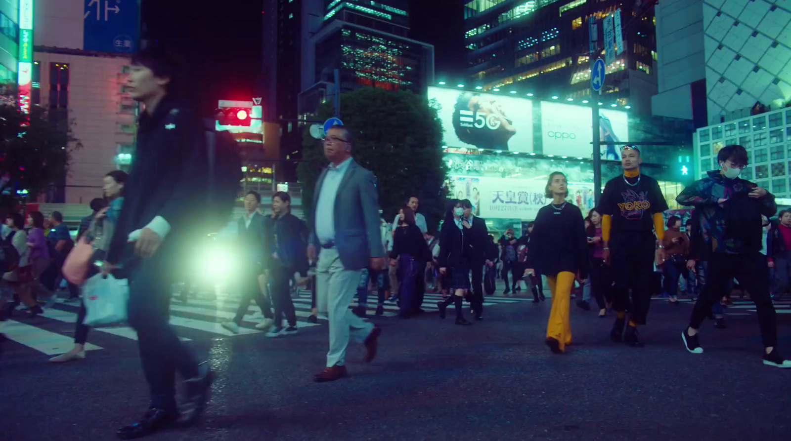 a group of people walking across a street at night