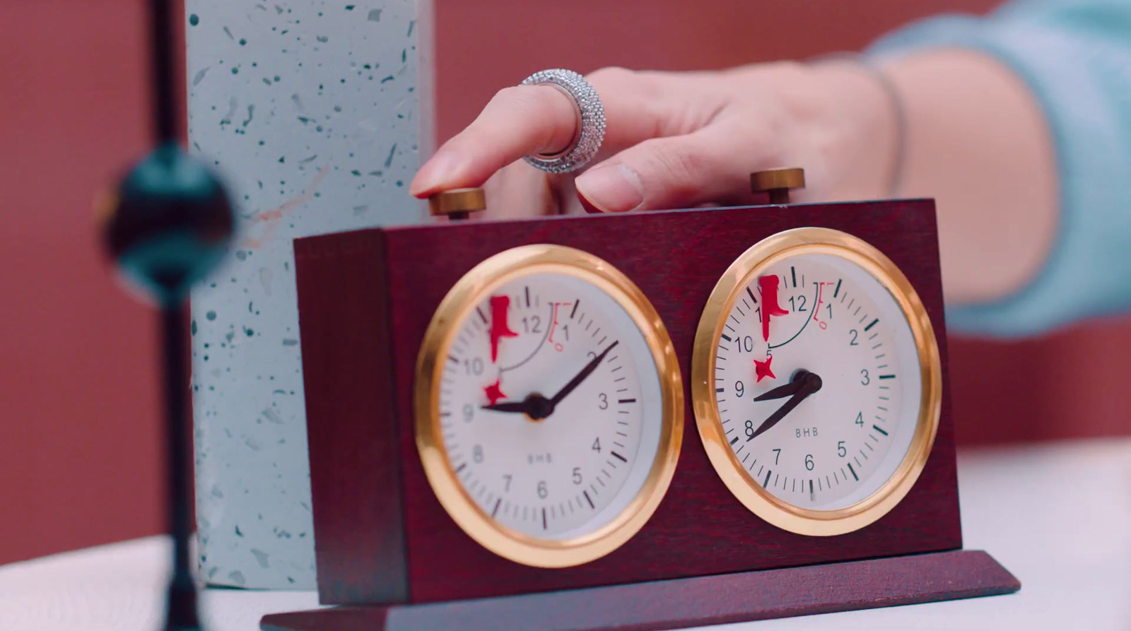 a person holding a clock on top of a table