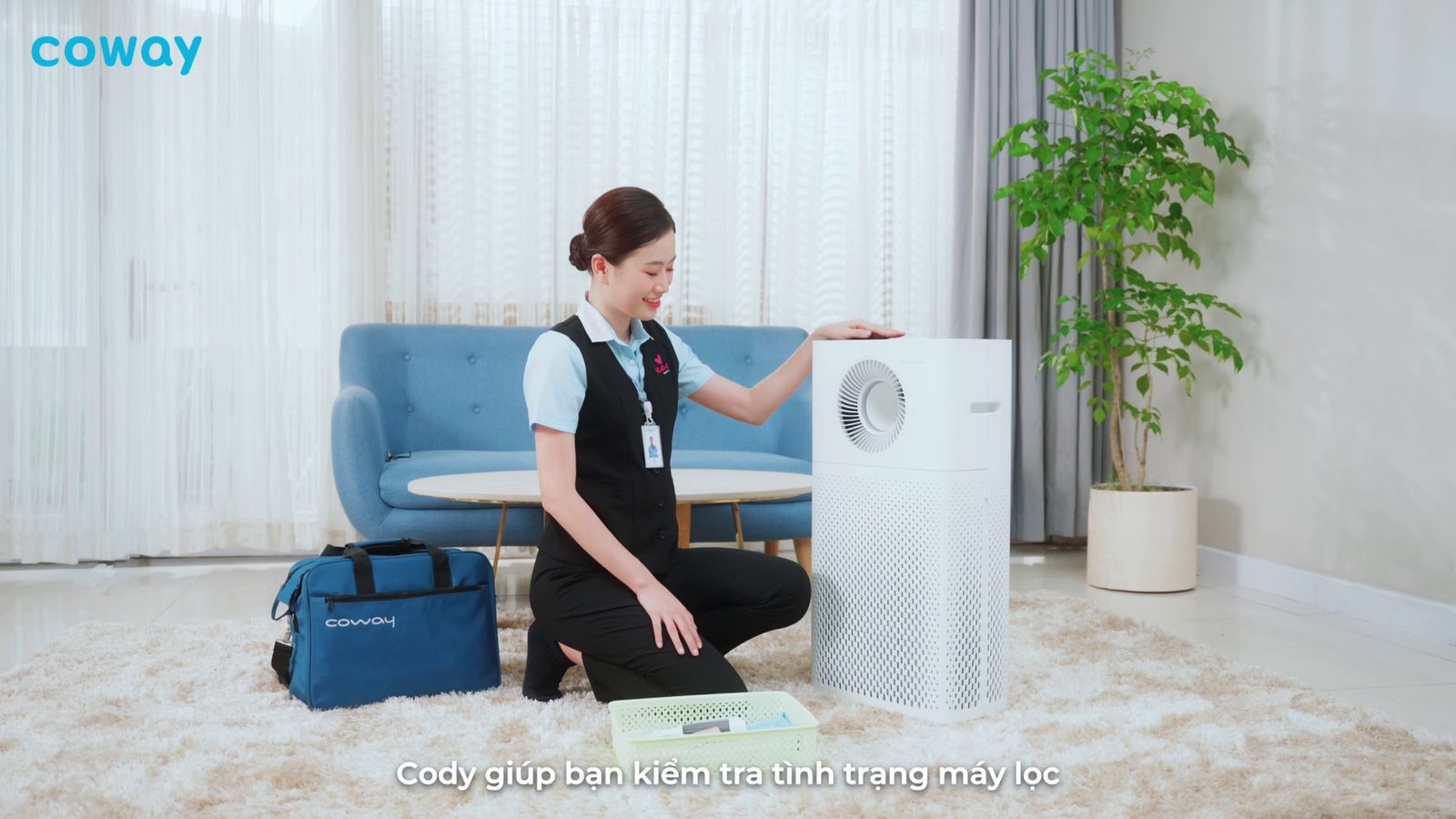 a woman sitting on the floor next to an air conditioner