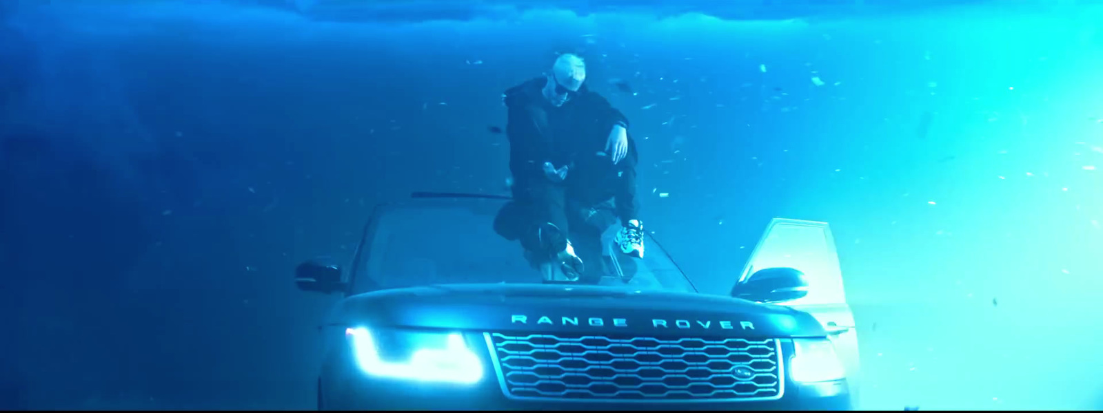 a man standing on top of a car under water