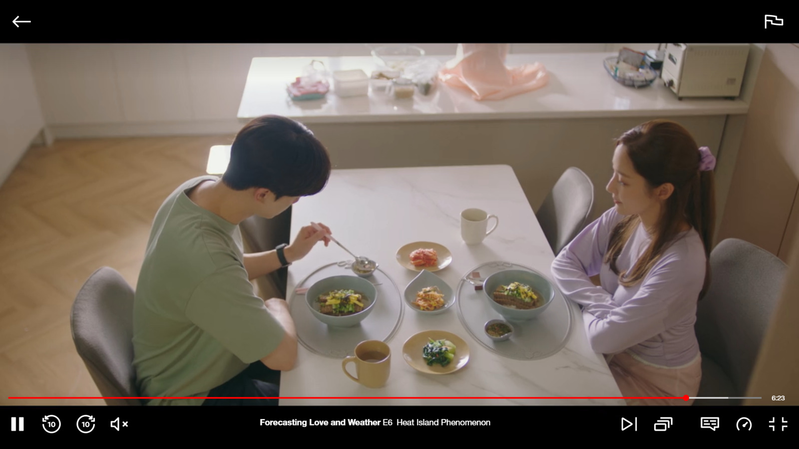 a man and a woman sitting at a table with food