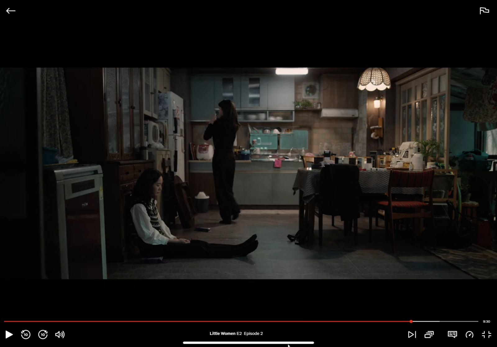 a woman sitting on the floor in a kitchen