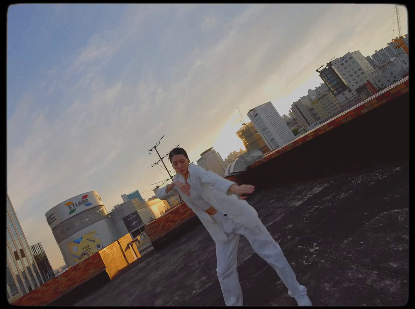 a man in a white suit standing on a roof