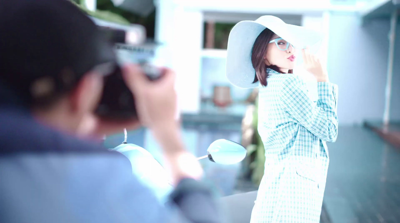 a woman in a white hat is taking a picture