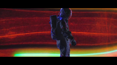 a man with a backpack standing in front of a red background