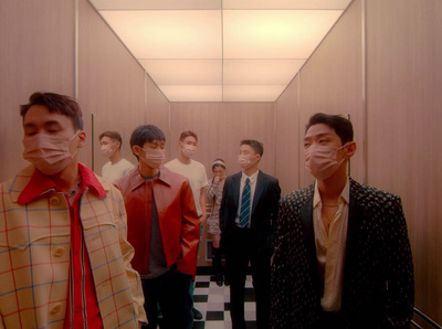 a group of men standing in a hallway wearing face masks