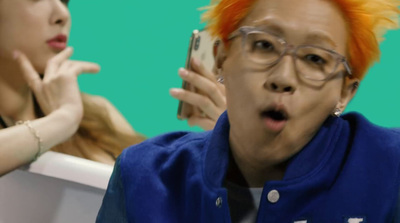 a man with orange hair and glasses holding a cell phone