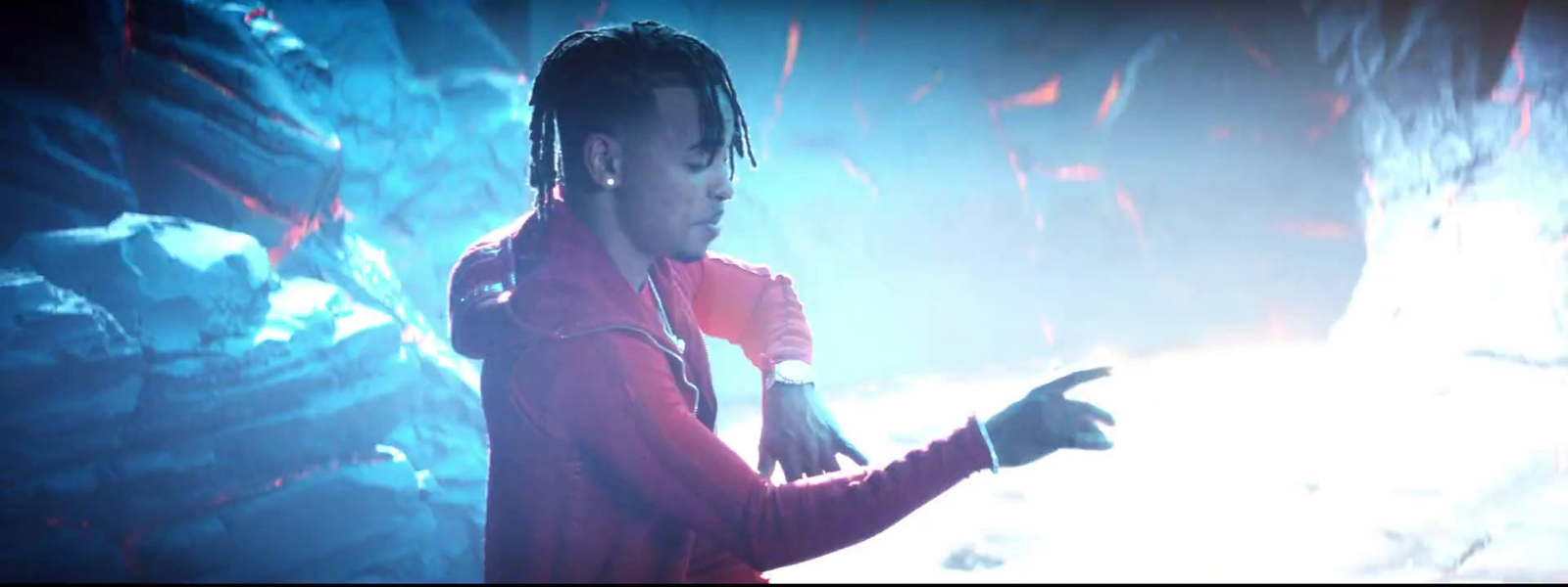 a man with dreadlocks standing in front of a stage