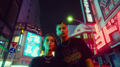 a man and a woman standing in the middle of a city at night