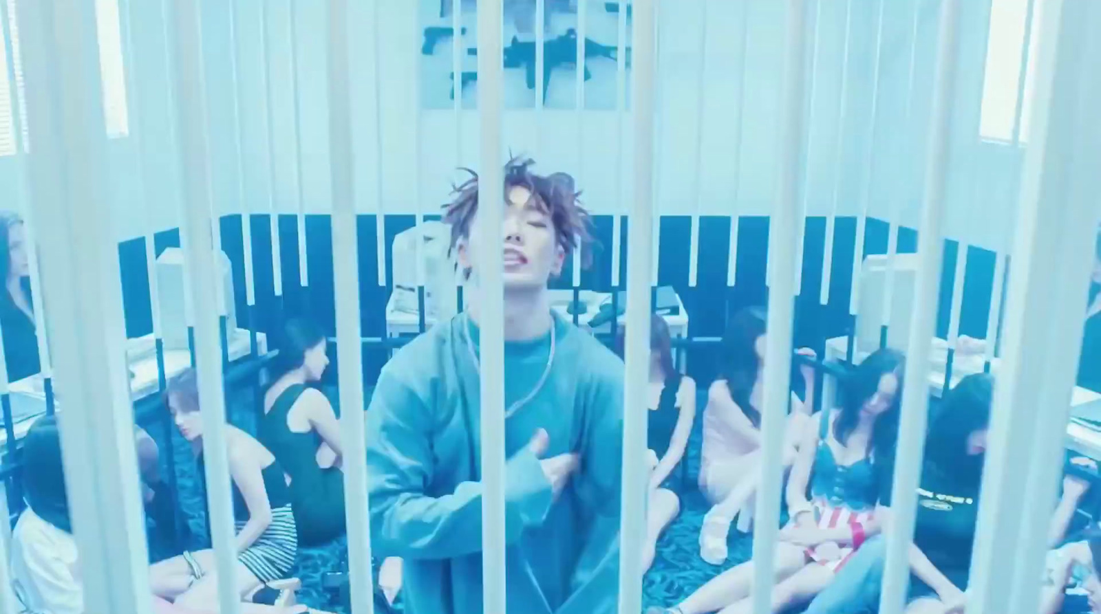 a group of people sitting in a room behind bars