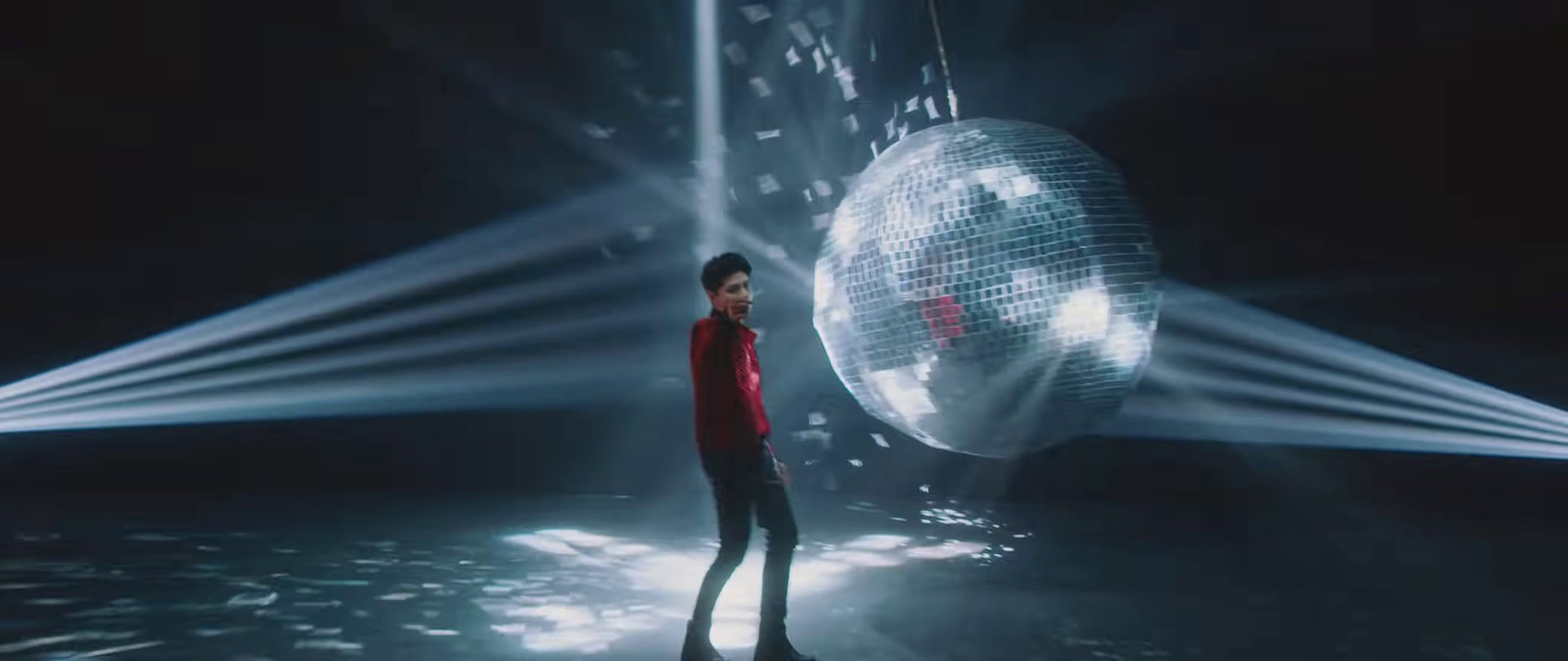 a man standing in front of a disco ball