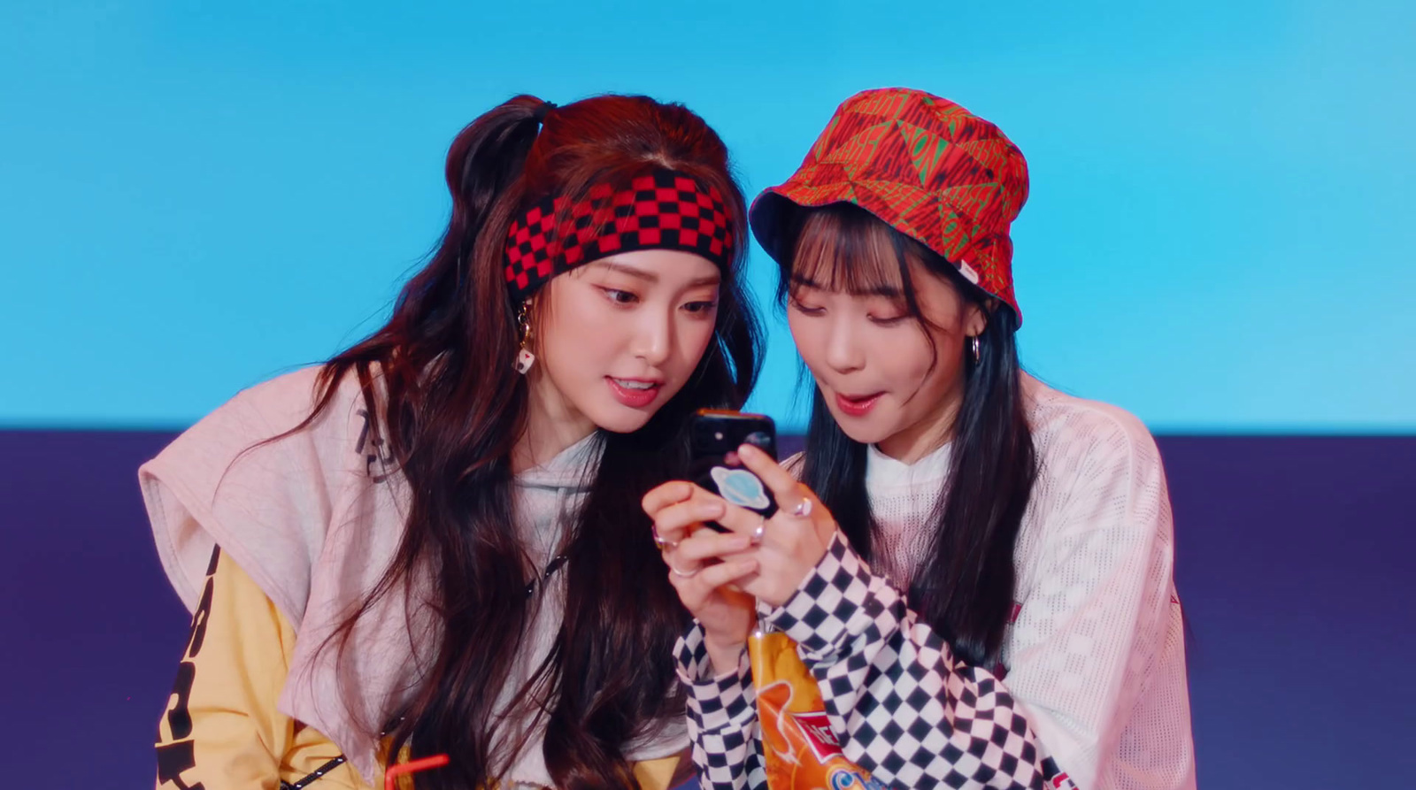 two asian girls looking at a cell phone