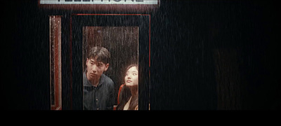 a man and a woman standing in a doorway in the rain