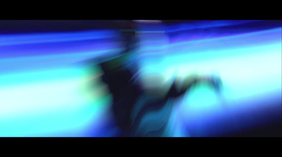 a blurry image of a person standing in front of a blue background