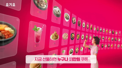 a woman standing in front of a pink wall with food on it