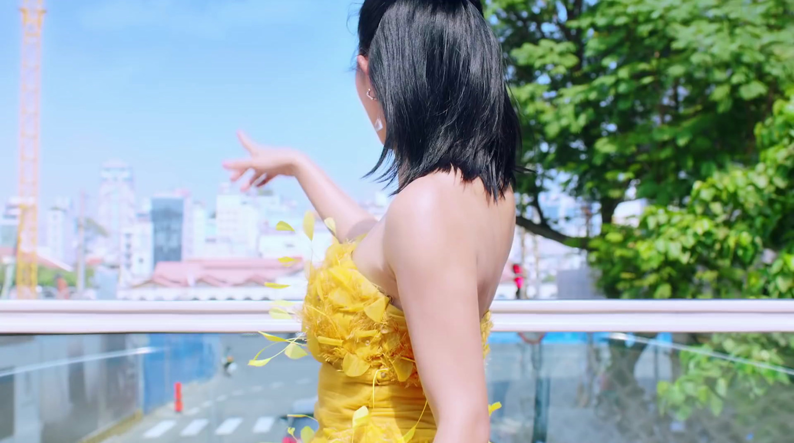 a woman in a yellow dress pointing at something