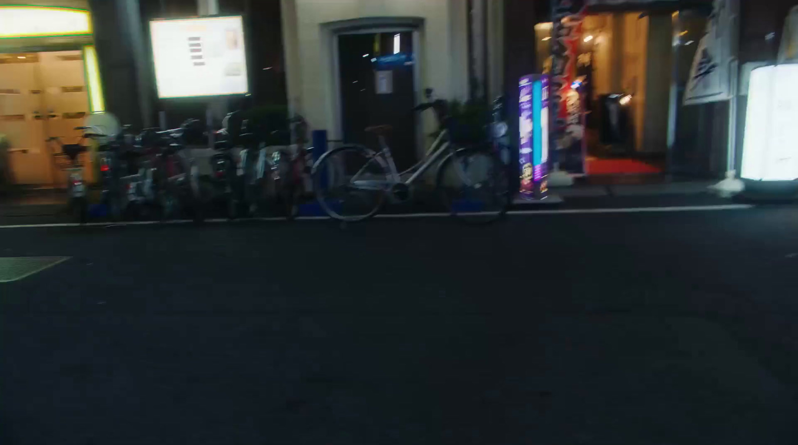 a row of bikes parked on the side of a street