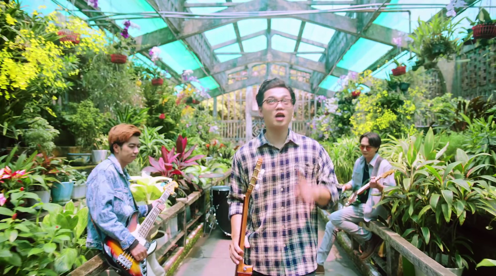 a group of people in a greenhouse with plants