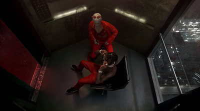 a man in a red suit sitting next to a man in a red suit