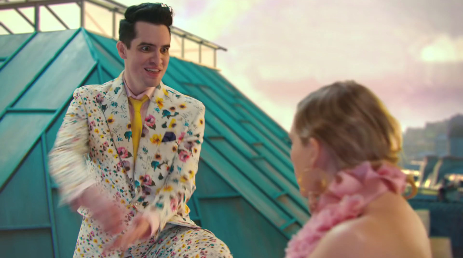 a man in a colorful suit is talking to a woman