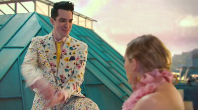 a man in a colorful suit is talking to a woman