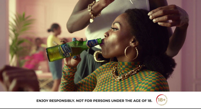 a woman is getting her hair done with a bottle of beer