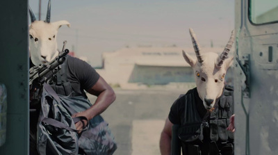 two men with goats on their heads walking down a street