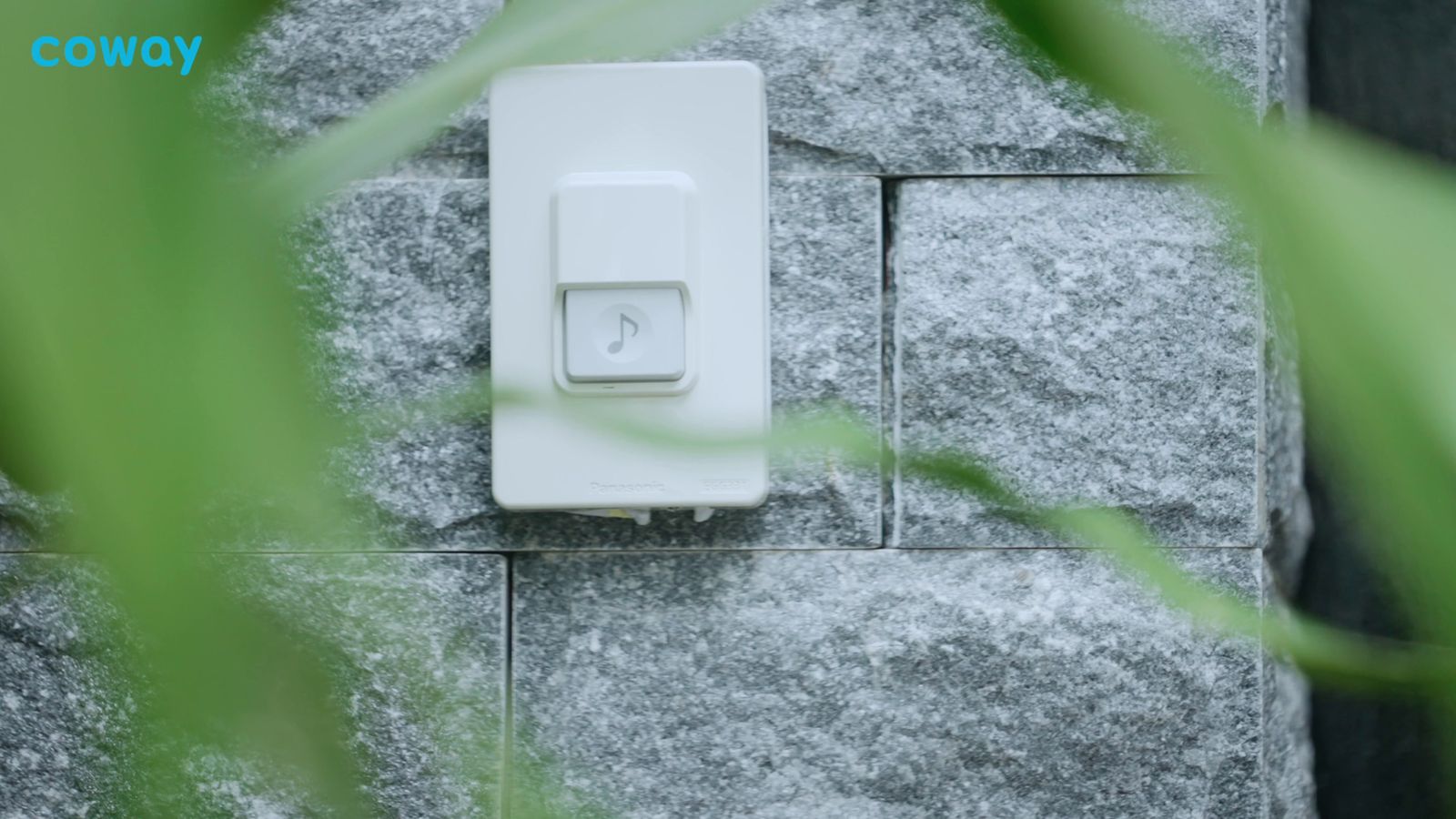 a white light switch on a stone wall