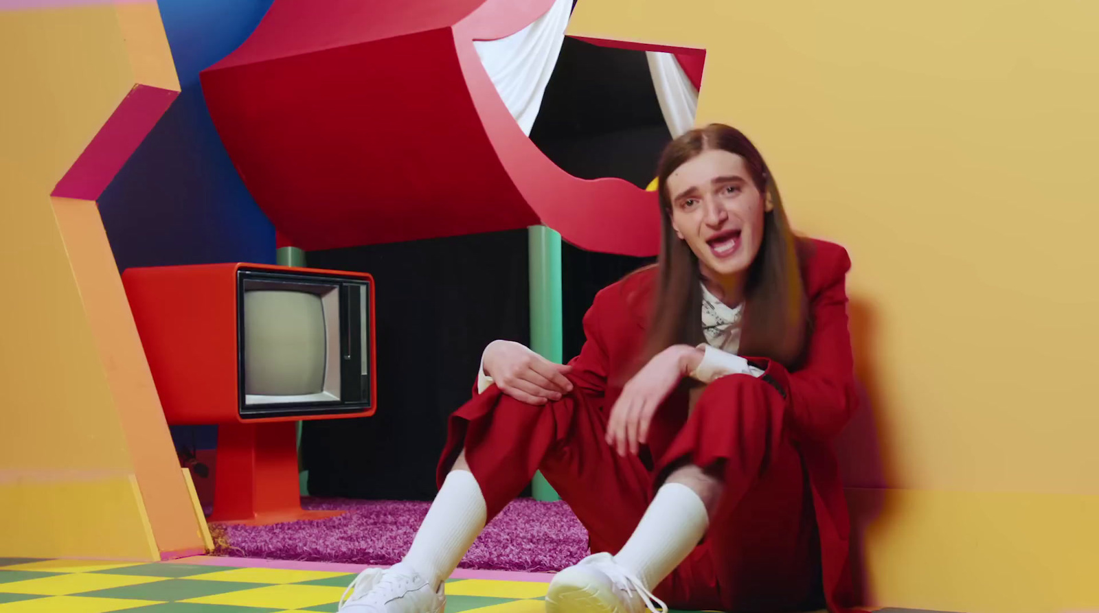 a woman sitting on the floor in front of a tv