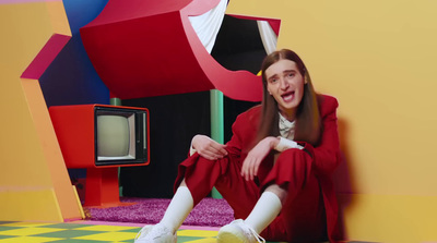 a woman sitting on the floor in front of a tv