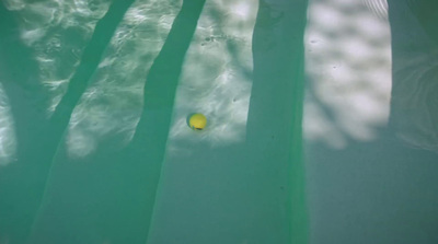 a yellow ball floating in a pool of water