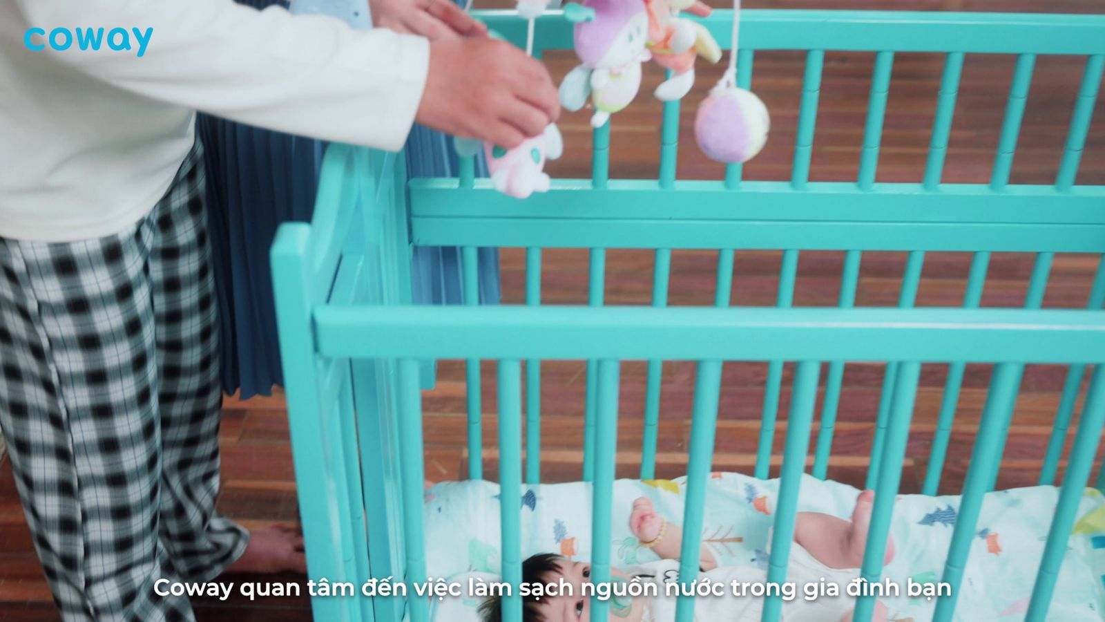 a person putting stuffed animals in a crib